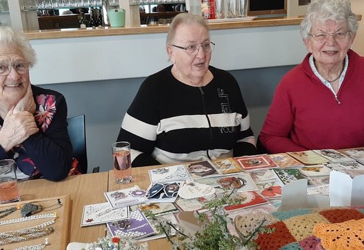 Drie vrouwen aan tafel met een drankje