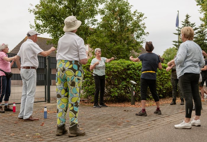 Deelnemers doen oefeningen onderweg