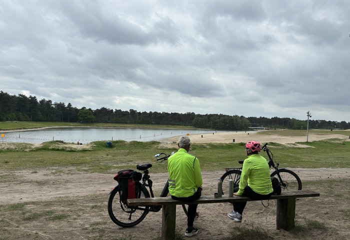 2 fietsers op een bankje bij de waterplas