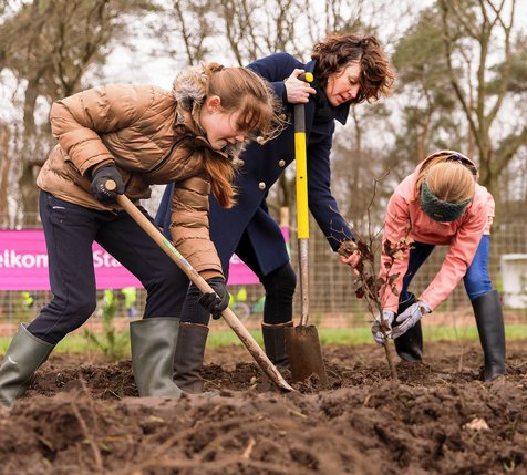 Burgemeester Lieke Schuitmaker plant boom samen met twee leerlingen