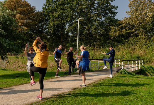 Deelnemers doen oefeningen onderweg